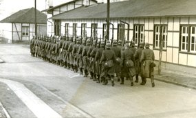 Section-du-regiment-en-marche-entre-les-baraquements-du-camp-de-Wahn-PM.jpg