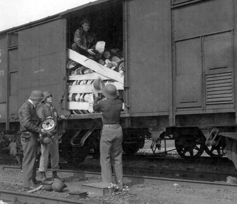 The trainload of helmets was at Wabern, Germany. The GIs are pilots from the 365th Fighter Group.jpg