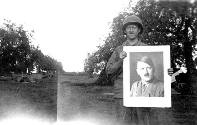 A G.I. holding a portrait of Adolf Hitler..jpg